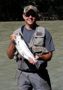 Veteran Jimmy Benedict holds fish at a river