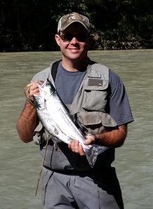 Veteran Jimmy Benedict holds fish at a river
